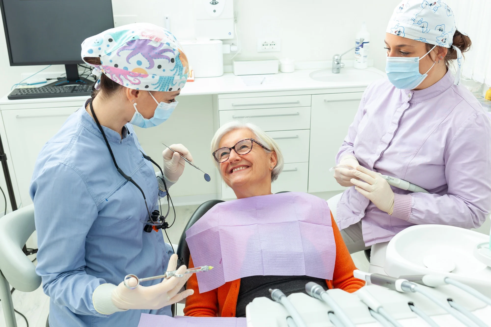 Dentists preparing senior woman for dental procedure